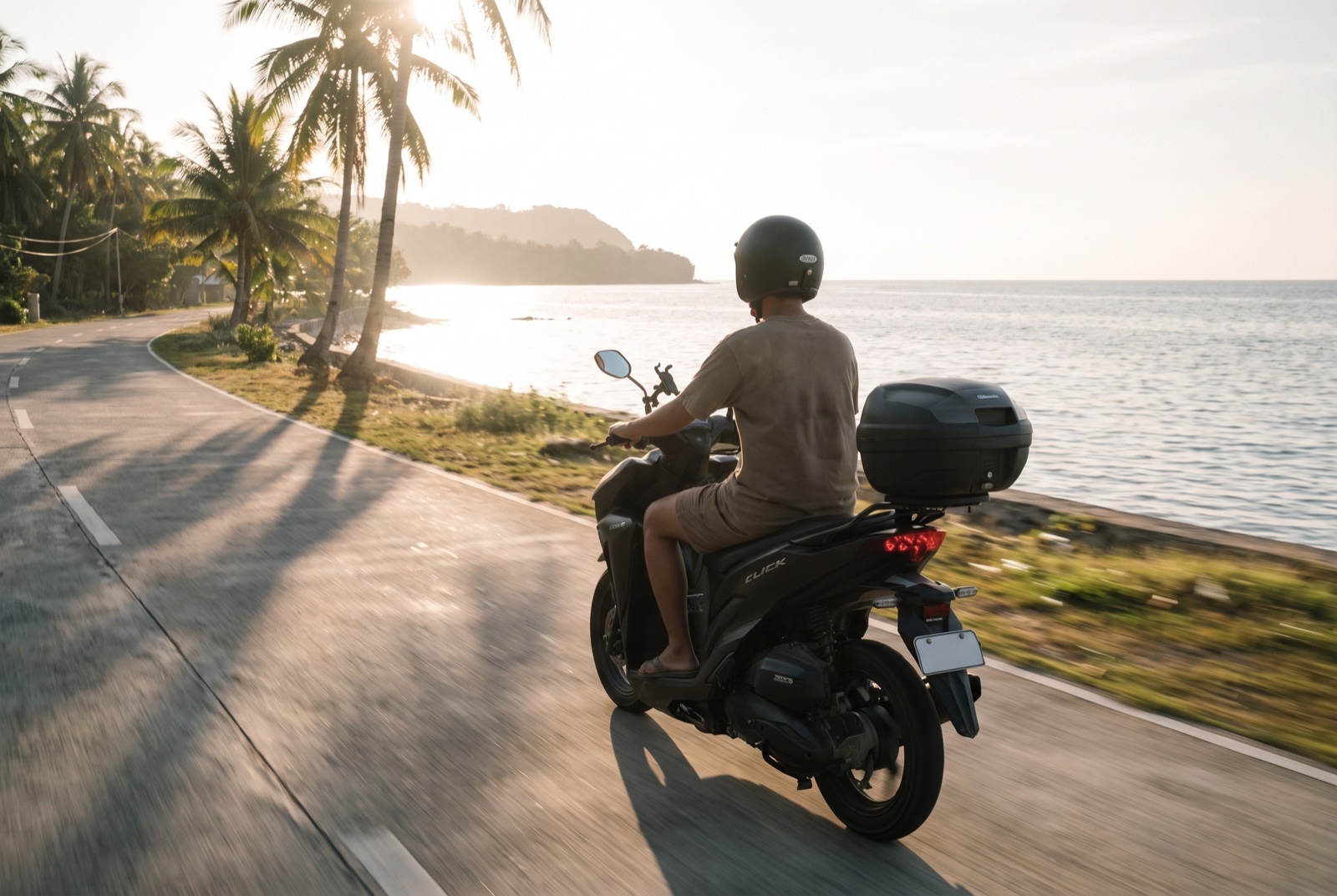 A rider on a Roam scooter riding the Siquijor coast road at golden hour